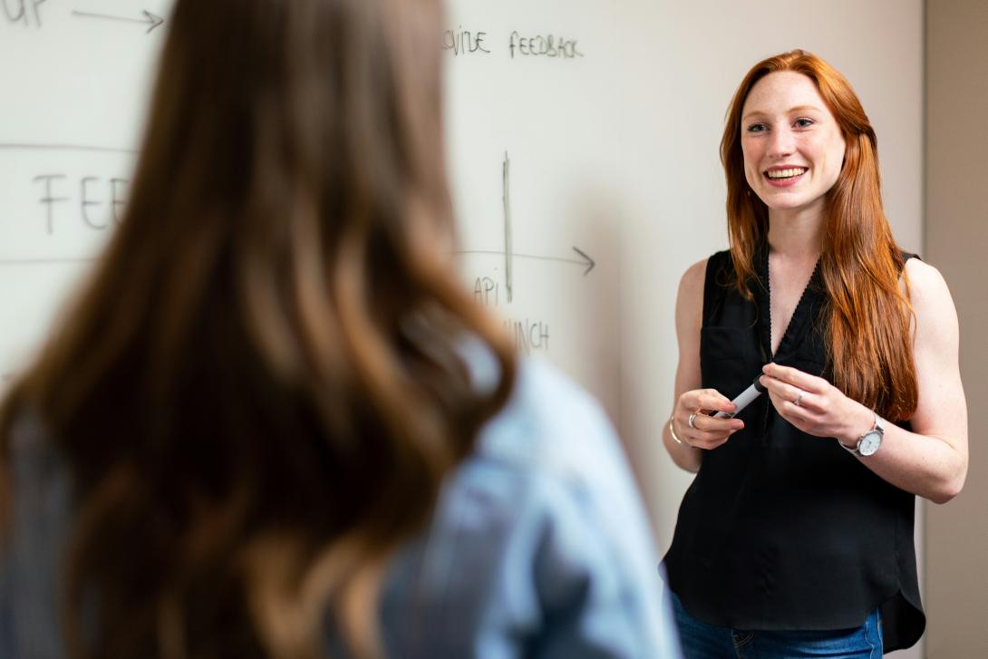 Red-headed teacher looking at student.